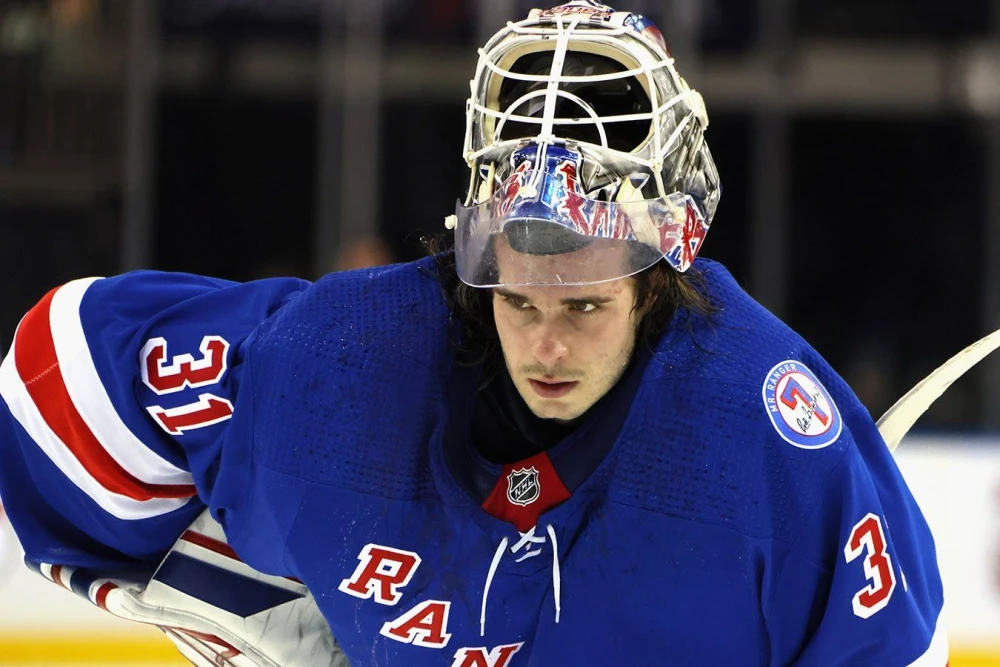 Российский вратарь Игорь Шестёркин в форме "Нью-Йорк Рейнджерс" отражает шайбу во время захватывающего матча НХЛ против "Нью-Джерси Дэвилз" на домашней арене "Мэдисон Сквер Гарден".
