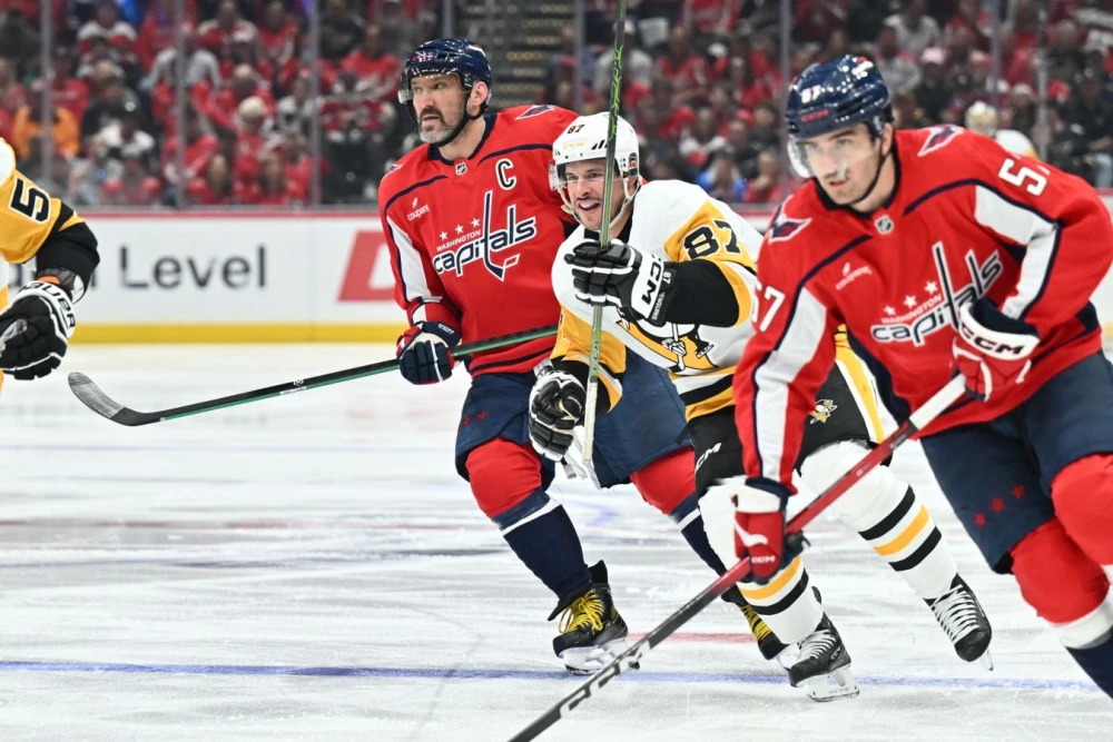 Александр Овечкин и Сидни Кросби на льду во время матча НХЛ, на заднем плане вратарь и другие игроки. Возможно, это их последнее противостояние.