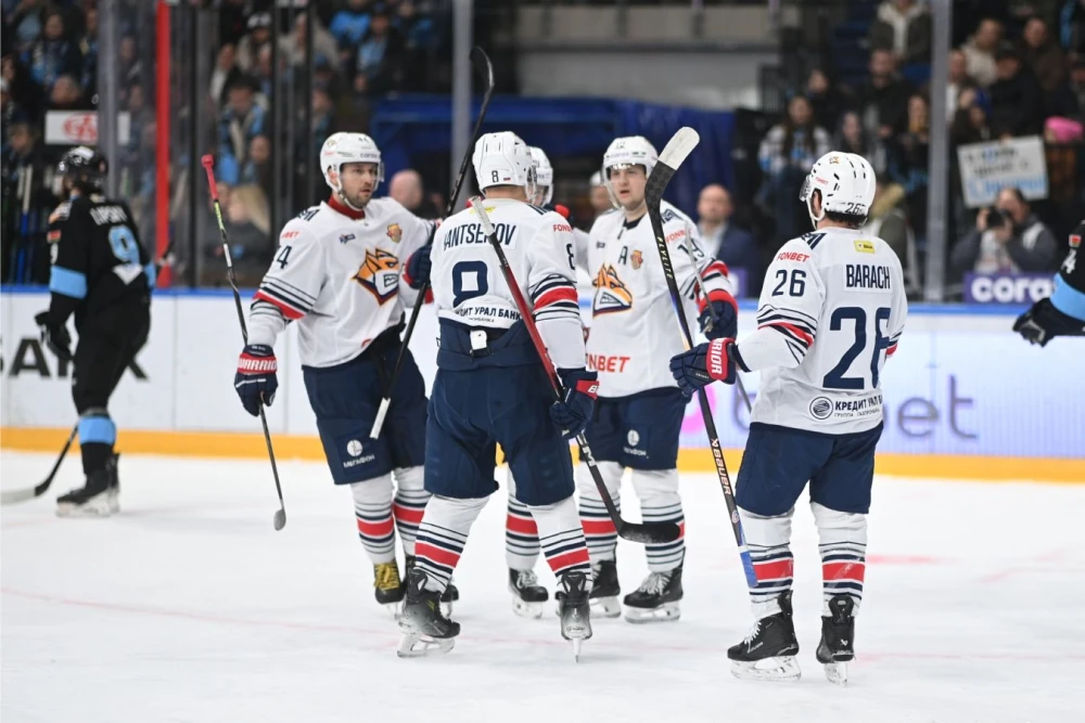 Вратарь Александр Смолин из команды «Металлург» празднует победу после матча КХЛ против «Динамо Минск», на табло отображен счет 3:0