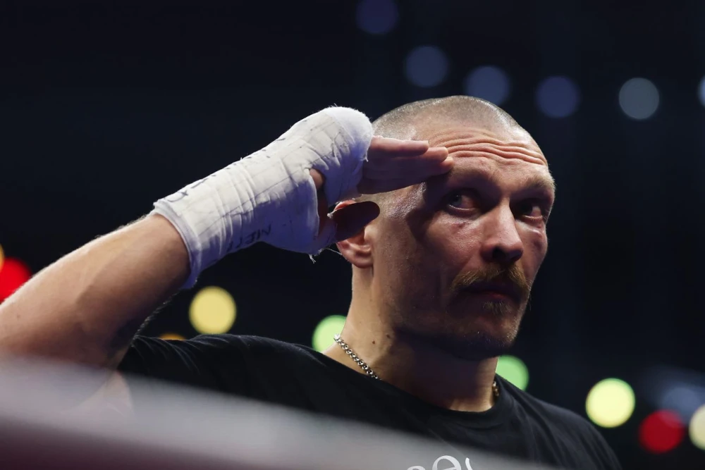 Александр Усик и Энтони Джошуа, два титана супертяжелого веса, на фоне стены желаний с надписью о чемпионстве, символизирующей их боксерскую судьбу.