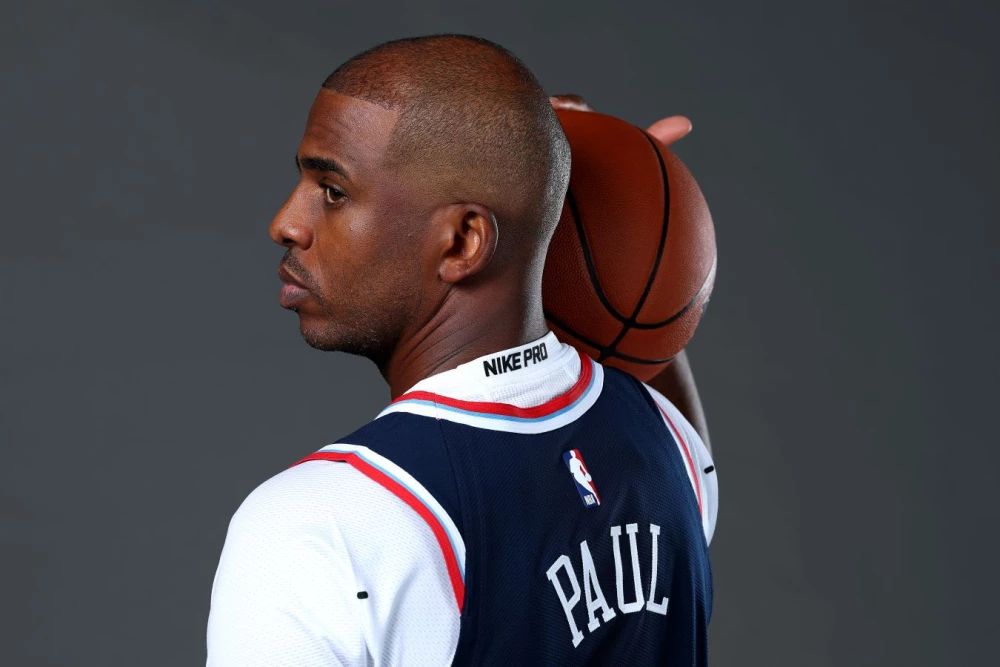 Адам Сильвер и Крис Пол на баскетбольной площадке или пресс-конференции, символизирующие прощание с легендой НБА